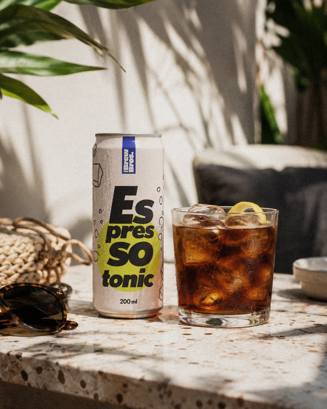 TBB-espresso-tonic-photo-2 Puszka Espresso Tonic The Brew Bros obok szklanki z napojem, lodem i plasterkiem cytryny